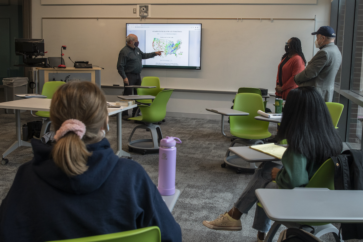 man standing at whiteboard during class