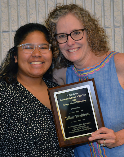 two women with a plaque