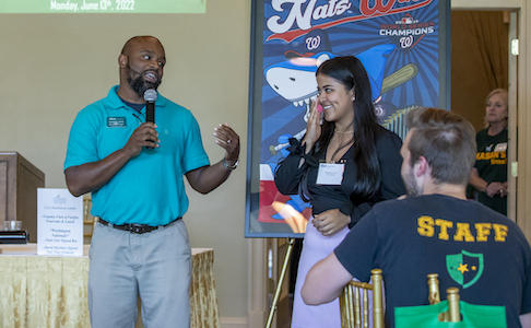 man with microphone introduces young woman