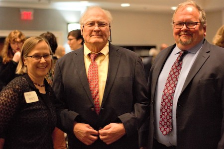 a woman and two men in suits