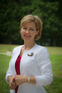 Ioulia Rytikova wears a white blazer and red blouse in her faculty profile for the Department of Information Sciences and Technology.