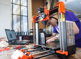 Student works with printer in the MIX at Mason