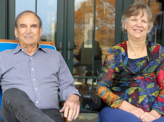 John and Tracie Jacquemin seated outside, smiling.